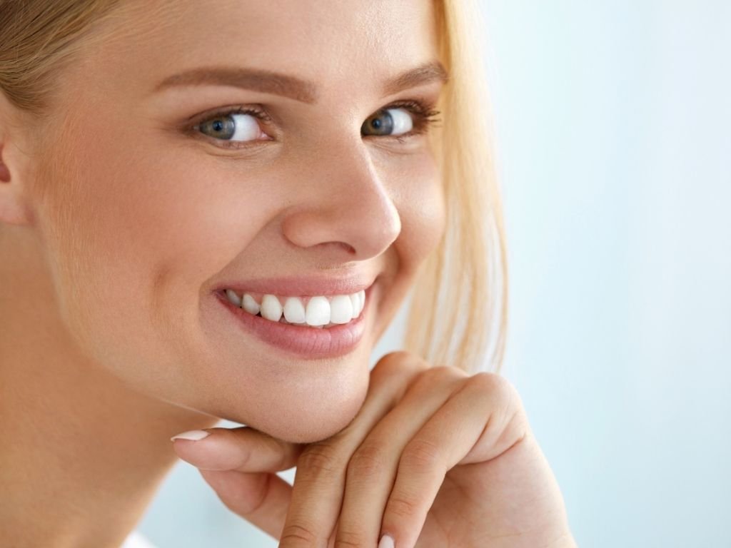 Mujer sonriendo demostrando salud bucal natural